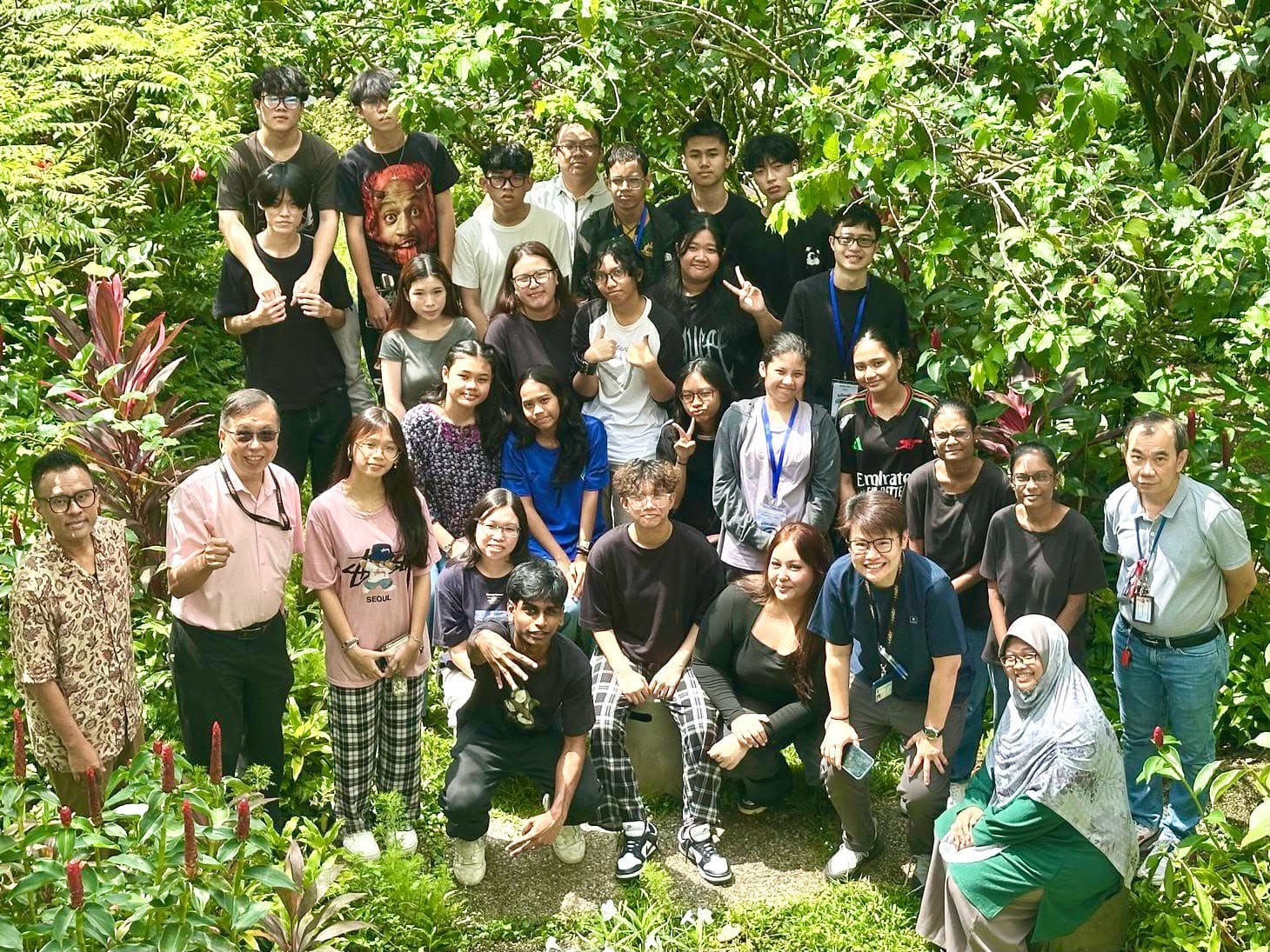 a group of young people with some adults looking up towards the camera